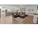 Spacious living room featuring a comfortable leather sectional and large windows for natural light at 1940 Bell Creek Loop, Fruitland Park, FL 34731