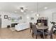 Open-concept living room with wood-look tile flooring, white sofa, and a view of the dining area at 1940 Bell Creek Loop, Fruitland Park, FL 34731