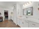 Bright main bathroom with double vanities, walk-in closet, and wood-look floors at 1940 Bell Creek Loop, Fruitland Park, FL 34731