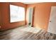 Bedroom with an orange wall, wood floors, and a closet with white folding doors at 2117 Lyme Bay Dr # 604, Orlando, FL 32839