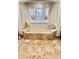 Relaxing primary bath featuring a tiled whirlpool tub and a window providing natural light at 2408 Dahlgren Way, Winter Garden, FL 34787