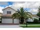 Charming two-story home featuring a three car garage, tile roof, and a tropical palm tree in the front yard at 2408 Dahlgren Way, Winter Garden, FL 34787