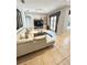 Cozy living room with white leather sofa, modern decor, and tiled flooring at 2408 Dahlgren Way, Winter Garden, FL 34787