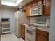 Cozy kitchen with wood cabinets, white appliances, and ample counter space at 2408 Lemon Tree Ln # C, Orlando, FL 32839