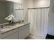 Elegant bathroom with double vanity, granite countertop, and white shower curtain at 2688 Magnolia Ave, Davenport, FL 33837