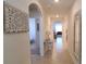 Inviting hallway with neutral walls, tile flooring, and an decorative mirror and artwork at 2688 Magnolia Ave, Davenport, FL 33837