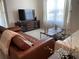 Comfortable living area with a leather sofa, natural light, and a flat-screen TV at 2688 Magnolia Ave, Davenport, FL 33837