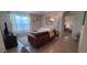 Inviting living room with a comfortable brown sofa, elegant decor, and ample natural light at 2688 Magnolia Ave, Davenport, FL 33837