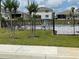 Community pool area with chairs, trees, and a black metal fence at 2688 Magnolia Ave, Davenport, FL 33837