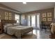 Cozy bedroom with neutral decor, leafy prints, desk, and sunny French doors at 3426 Somerset Ave, Deltona, FL 32738
