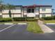 Well-maintained two-story condo building with landscaping, palm trees, and visible parking area at 3475 Flossmoor Ave # 103, Orlando, FL 32822