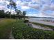 Picturesque community grounds with a scenic lake view, sandy shore, and mature landscaping at 3475 Flossmoor Ave # 103, Orlando, FL 32822