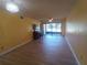 This living room features wood-look floors, yellow walls, and access to a screened-in patio at 3475 Flossmoor Ave # 103, Orlando, FL 32822