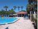 Inviting community pool surrounded by lush landscaping, seating, and a cabana at 3475 Flossmoor Ave # 103, Orlando, FL 32822