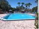 Community pool surrounded by lounge chairs and manicured landscaping on a sunny day at 3475 Flossmoor Ave # 103, Orlando, FL 32822