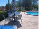 Community pool with lounge chairs, tables, and lush landscaping for relaxation at 3475 Flossmoor Ave # 103, Orlando, FL 32822