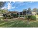 Well-maintained lawn leading to a home with a screened-in patio at 39342 Harbor Hills Blvd, Lady Lake, FL 32159
