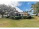 Landscaped backyard featuring a screened-in patio and lush green lawn at 39342 Harbor Hills Blvd, Lady Lake, FL 32159