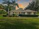 Charming home featuring a manicured lawn, lush landscaping, and decorative window accents enhancing its curb appeal at 39342 Harbor Hills Blvd, Lady Lake, FL 32159