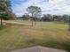 Elevated perspective of a lush golf course with scattered trees and blue skies in the background at 39342 Harbor Hills Blvd, Lady Lake, FL 32159