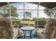 Screened-in patio with comfortable seating and a picturesque view of the golf course at 39342 Harbor Hills Blvd, Lady Lake, FL 32159