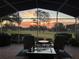 Covered patio featuring comfortable seating and views of a golf course with a stunning sunset at 39342 Harbor Hills Blvd, Lady Lake, FL 32159