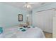 Bright bedroom featuring a bed with floral bedding, mirrored wall decor, and a ceiling fan at 424 Valverda Dr, The Villages, FL 32162