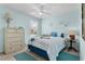 Light blue bedroom with ceiling fan, a dresser, and a cozy bed at 424 Valverda Dr, The Villages, FL 32162