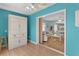 Bonus room features blue accent wall with built-in cabinet and pass-through to the living room at 424 Valverda Dr, The Villages, FL 32162