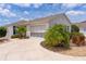 Home exterior showcasing a concrete driveway, palm trees, and manicured landscaping at 424 Valverda Dr, The Villages, FL 32162
