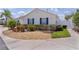 Home exterior featuring blue shutters, landscaped yard with gravel and lawn at 424 Valverda Dr, The Villages, FL 32162
