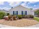 Charming one-story home with blue shutters and a meticulously maintained front yard at 424 Valverda Dr, The Villages, FL 32162