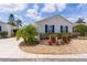 Charming home with manicured landscaping, gravel accents, and bright blue shutters at 424 Valverda Dr, The Villages, FL 32162