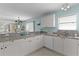 Modern kitchen with white cabinets, granite countertops, and an open view into the dining area at 424 Valverda Dr, The Villages, FL 32162