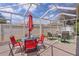 Covered patio with ample seating, table with umbrella, and view of partially fenced backyard at 424 Valverda Dr, The Villages, FL 32162