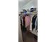 Walk-in closet with rods and shelves, full of clothes and some stored items at 4300 Aqua Vista Dr # A, Orlando, FL 32839