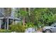 Condo exterior is surrounded by bamboo, banana trees, and other lush greenery with a parked car at 4300 Aqua Vista Dr # A, Orlando, FL 32839