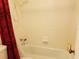 A clean bathtub and shower combination featuring a decorative red shower curtain at 4302 Aqua Vista Dr # G, Orlando, FL 32839