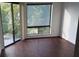 Comfortable bedroom with dark floors, a window with nature views, and a sliding door to a balcony at 4302 Aqua Vista Dr # G, Orlando, FL 32839