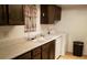 A compact kitchenette featuring wood cabinets, a stainless steel sink, and a washer/dryer at 4302 Aqua Vista Dr # G, Orlando, FL 32839