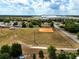 Aerial view showcasing a community baseball field bordered by homes and green trees, with a large warehouse in the distance at 4680 Sw 142 Place Rd, Ocala, FL 34473