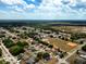 Expansive aerial view of neighborhood homes, streets, and a baseball field bordered by lush trees under a partly cloudy sky at 4680 Sw 142 Place Rd, Ocala, FL 34473