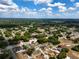 Panoramic aerial view capturing a residential area featuring tree-lined streets and neatly arranged houses under a blue sky with clouds at 4680 Sw 142 Place Rd, Ocala, FL 34473