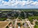 An aerial view of a community with homes and roads amid green landscapes under a blue sky at 4680 Sw 142 Place Rd, Ocala, FL 34473
