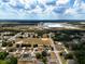 Overhead shot of neighborhood with a commercial structure, and tree-lined streets under a blue sky at 4680 Sw 142 Place Rd, Ocala, FL 34473