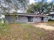 Backyard view with a sliding glass door leading to a small patio, and a gray exterior at 4680 Sw 142 Place Rd, Ocala, FL 34473