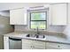 Charming kitchen featuring a stainless steel sink, granite countertops, and white cabinets at 4680 Sw 142 Place Rd, Ocala, FL 34473