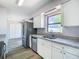 Updated kitchen features stainless steel appliances, granite countertops, and white cabinets at 4680 Sw 142 Place Rd, Ocala, FL 34473