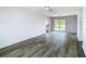 Open living room with wood-look flooring and a view to the kitchen through the doorway at 4680 Sw 142 Place Rd, Ocala, FL 34473