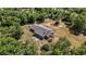An aerial view reveals a backyard containing a shuffleboard court and bordered by a home with mature tree coverage at 5155 Holopaw Rd, St Cloud, FL 34773